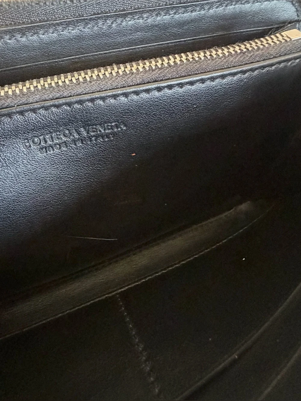 BOTTEGA VENETA Black Zip Around Wallet in Intrecciato Debossed Calfskin. UNISEX.